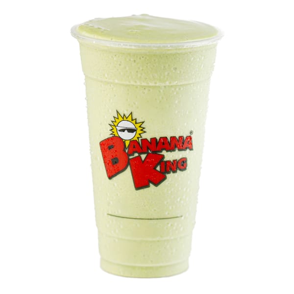 A Banana King green smoothie in a clear plastic cup with condensation, against a white background.