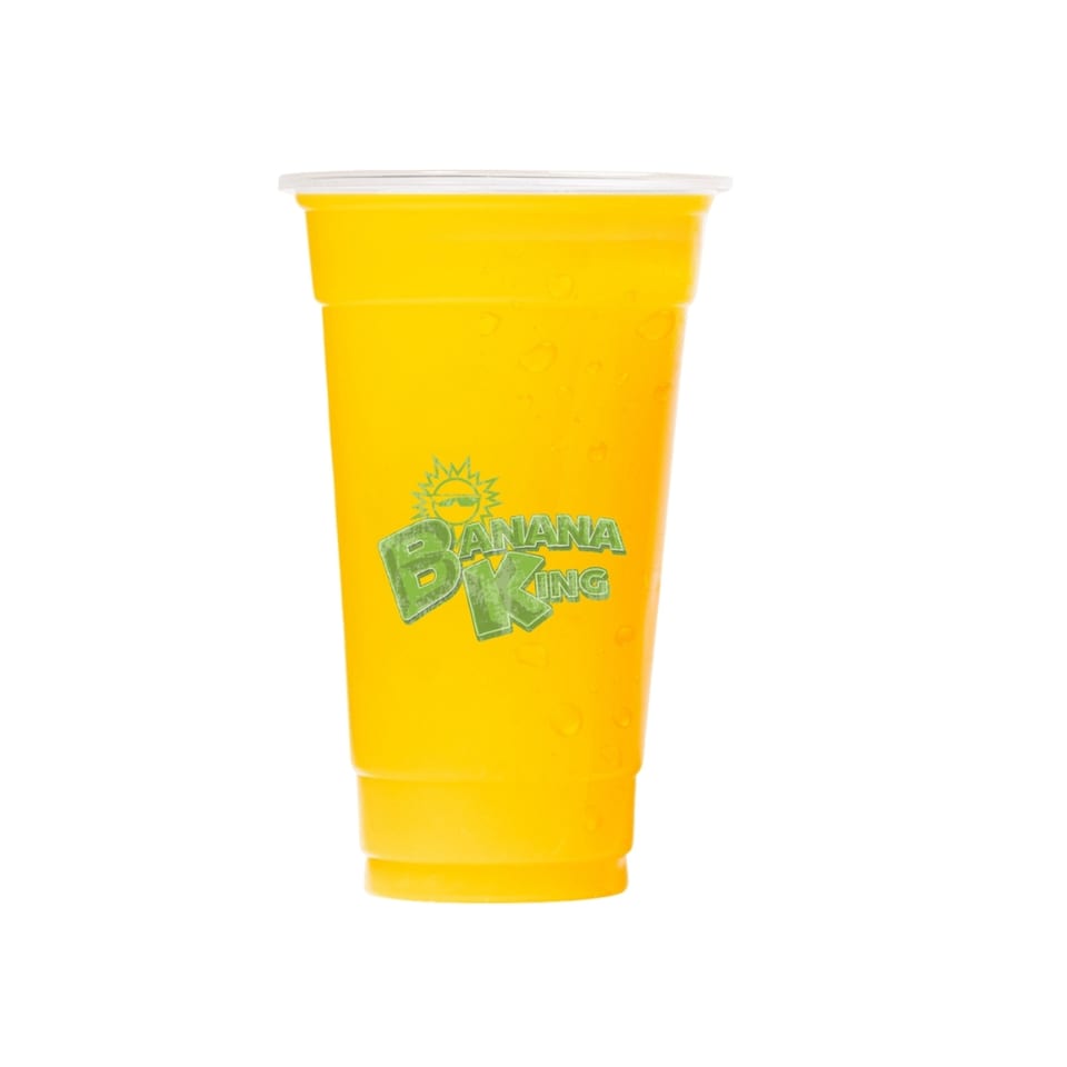 A Banana King banana smoothie in a clear plastic cup with the logo, against a white background.