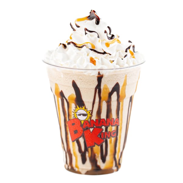 Banana King milkshake with whipped cream, chocolate, and caramel drizzle in a branded cup.